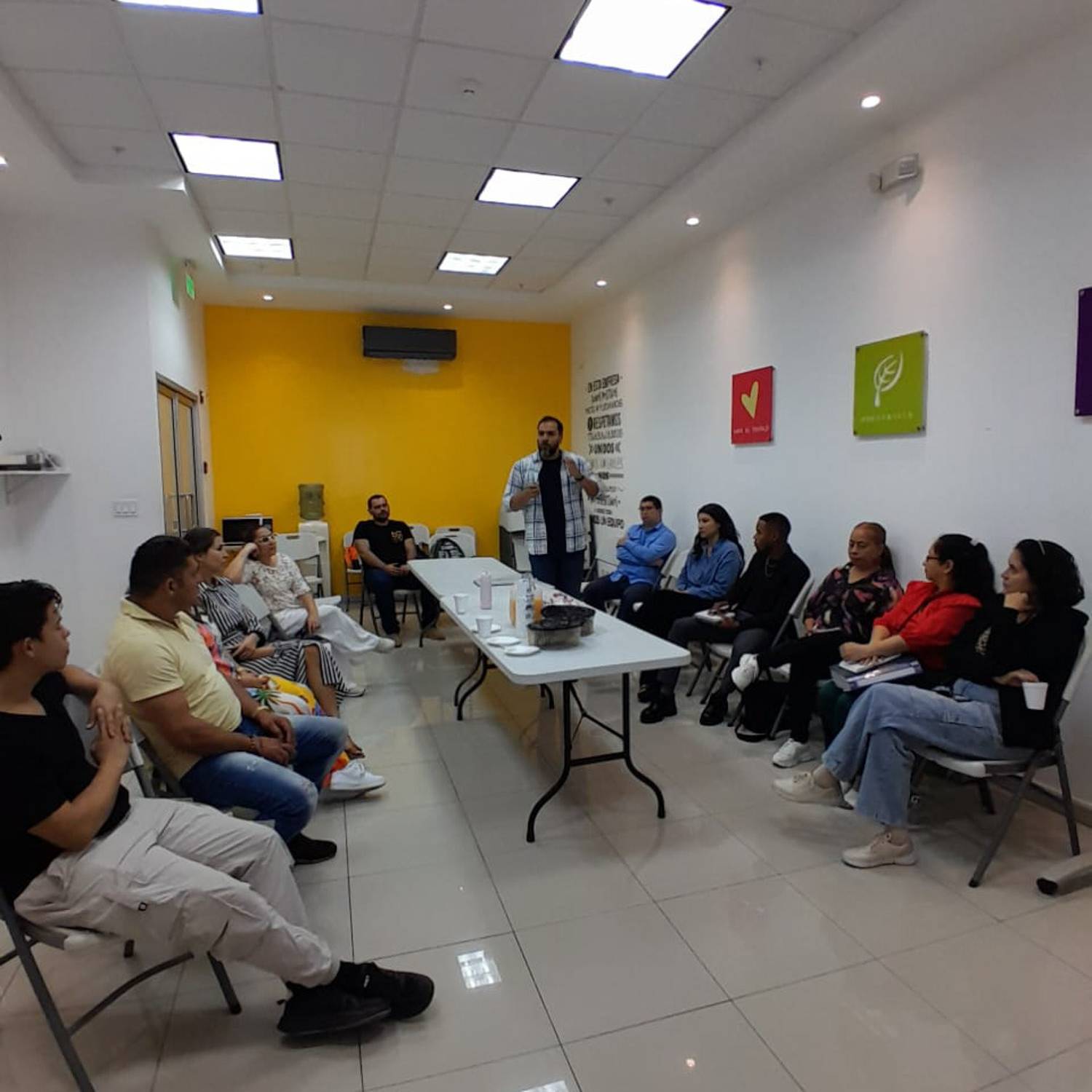 Grupo de personas en una sesión formativa y de diálogo organizada por la Fundación Estudio TAC en un salón de reuniones con un facilitador exponiendo al fondo.