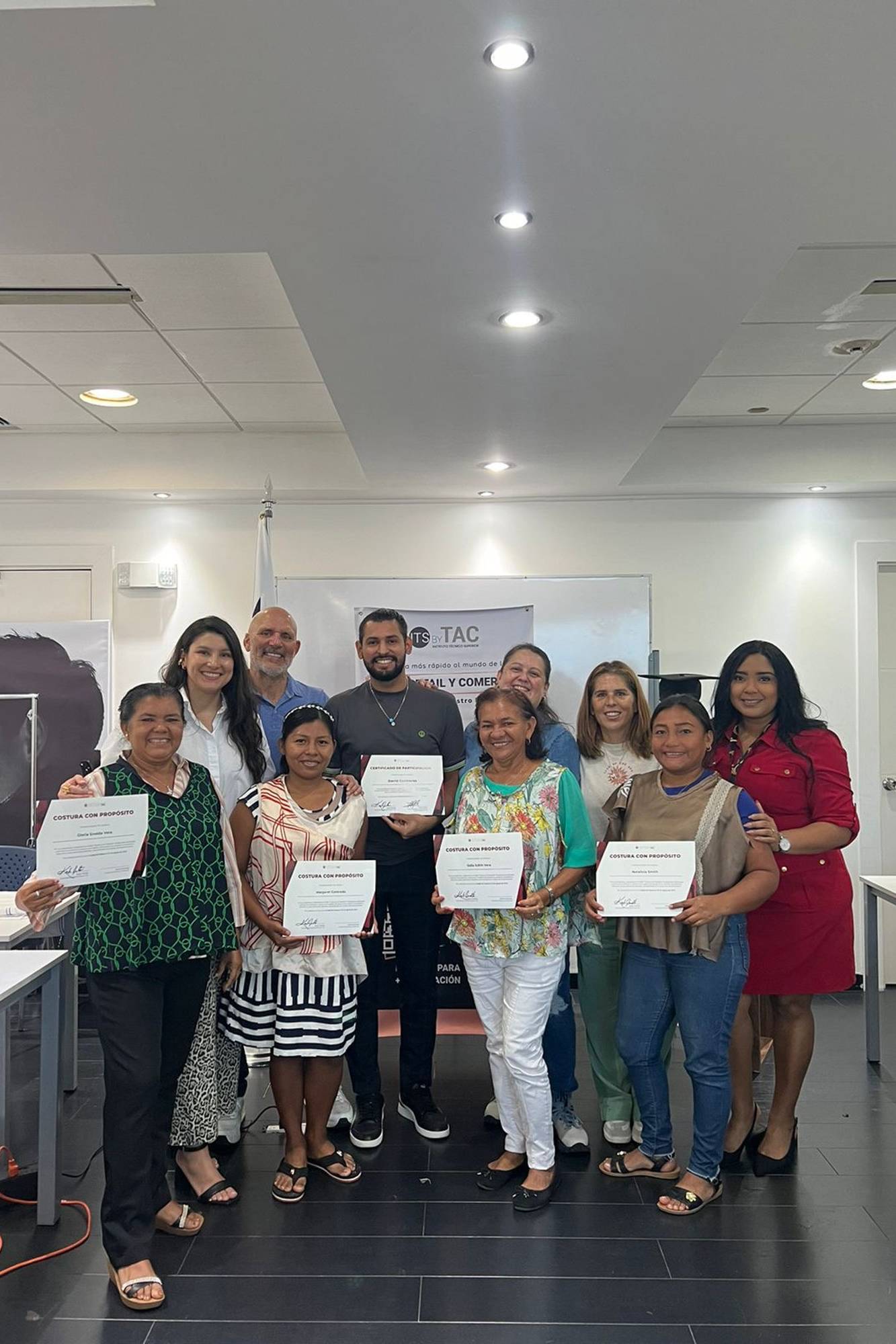 Un grupo de participantes y facilitadores posa con orgullo mostrando sus diplomas de Costura con Prop&oacute;sito en el acto de certificaci&oacute;n del programa Yo Aprendo.