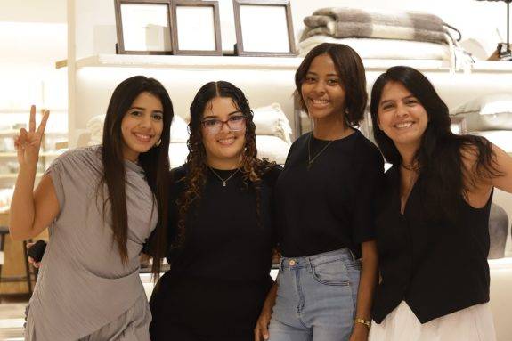 Un grupo de cuatro mujeres sonríe y posa junta en un establecimiento comercial de diseño de interiores durante una actividad práctica del programa Yo Aprendo.