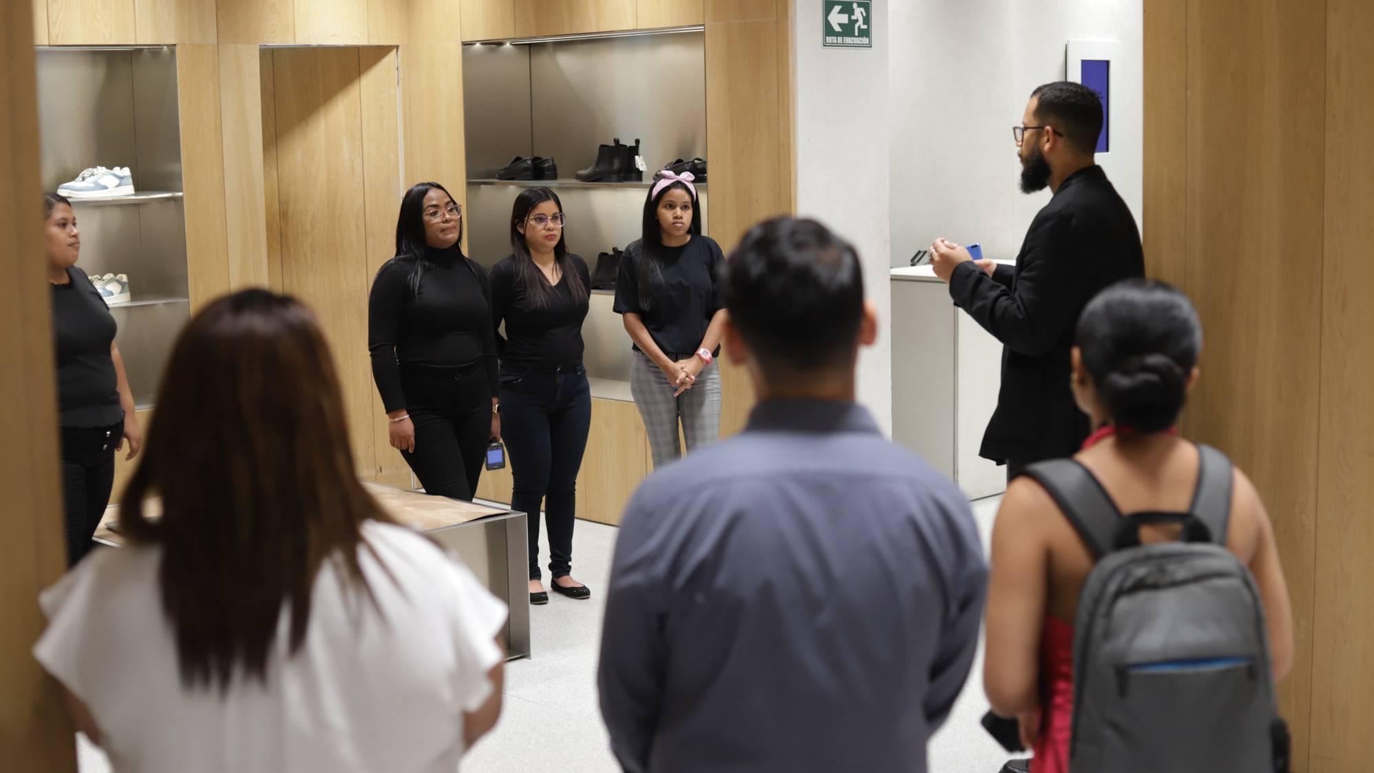Un instructor dicta una capacitaci&oacute;n pr&aacute;ctica sobre atenci&oacute;n al cliente y retail en una tienda comercial a estudiantes del programa Yo Aprendo de la Fundaci&oacute;n Estudio TAC.