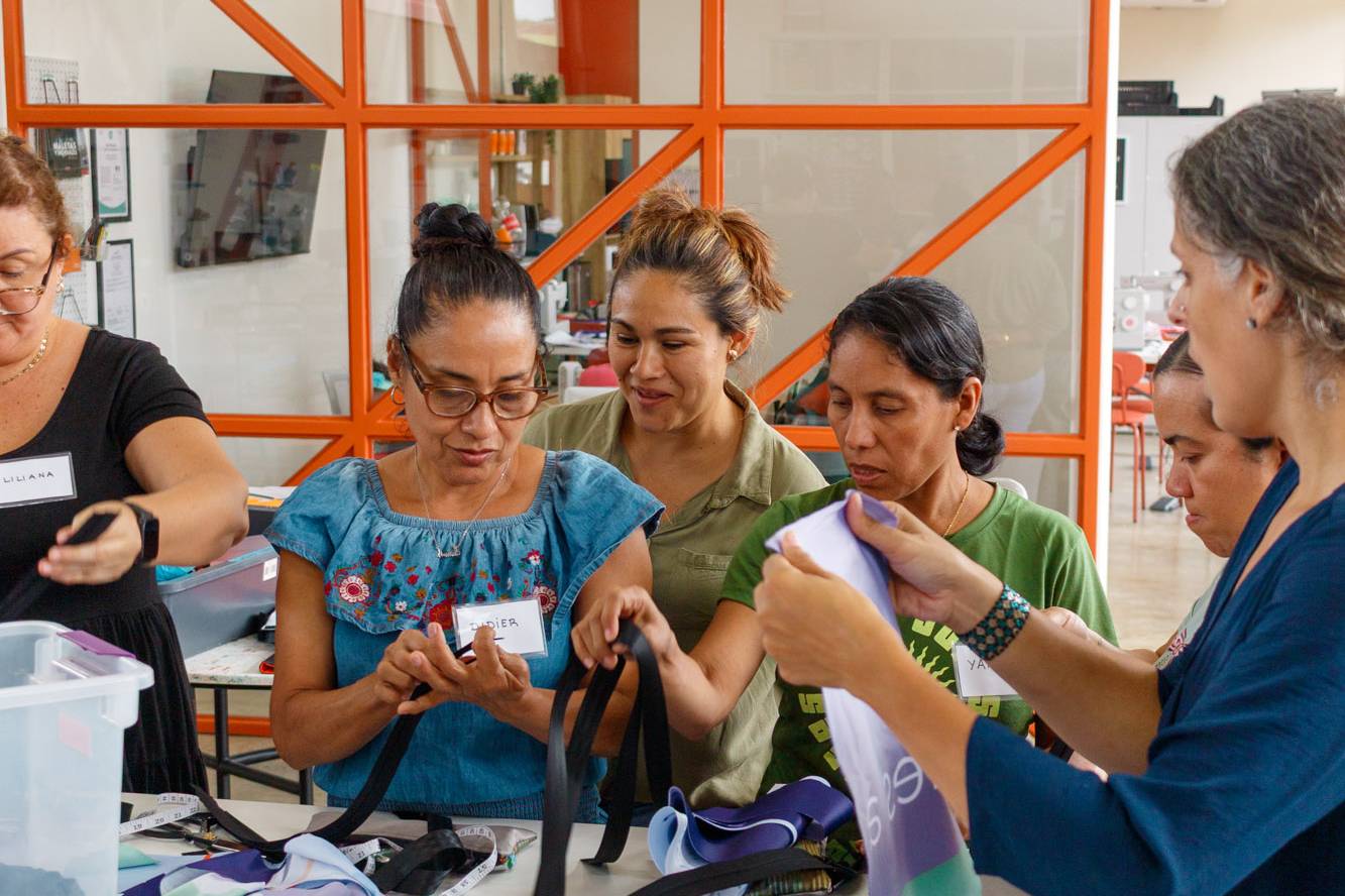 Grupo de mujeres participan en un taller práctico de costura y confección textil del programa Yo Aprendo de la Fundación Estudio TAC.